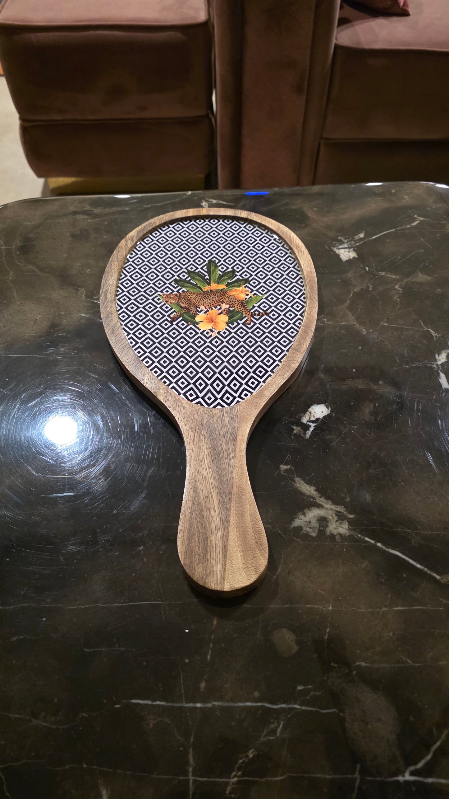 Wooden platter with botanical floral design on a dark surface