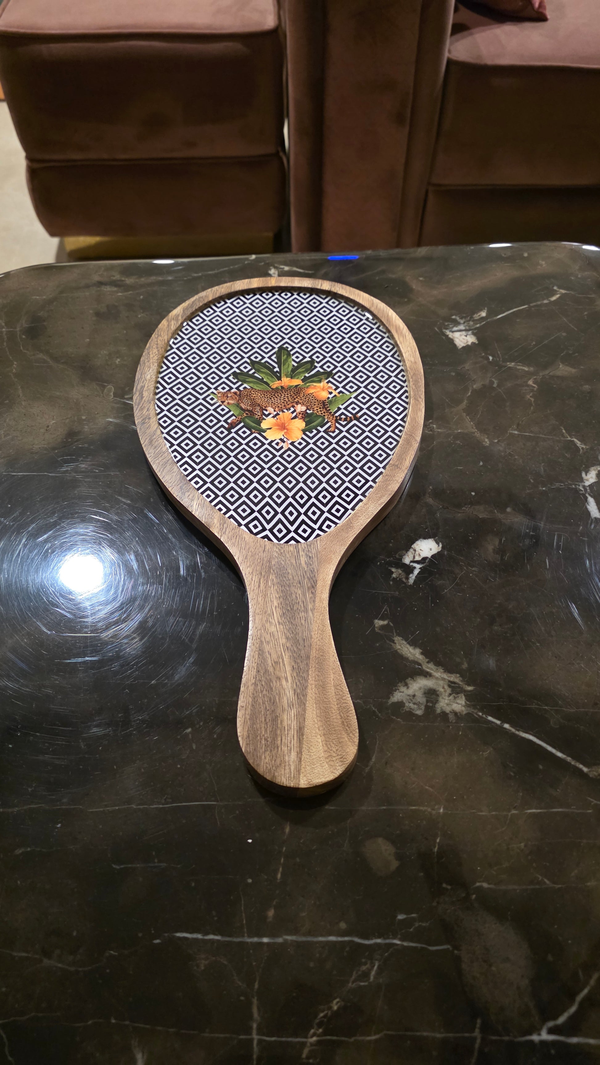 Wooden platter with botanical floral design on a dark surface