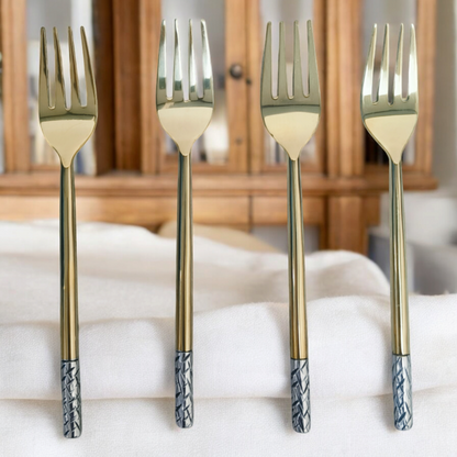 Samaa India luxury dinner fork set with gold finish and patterned silver handles on white fabric