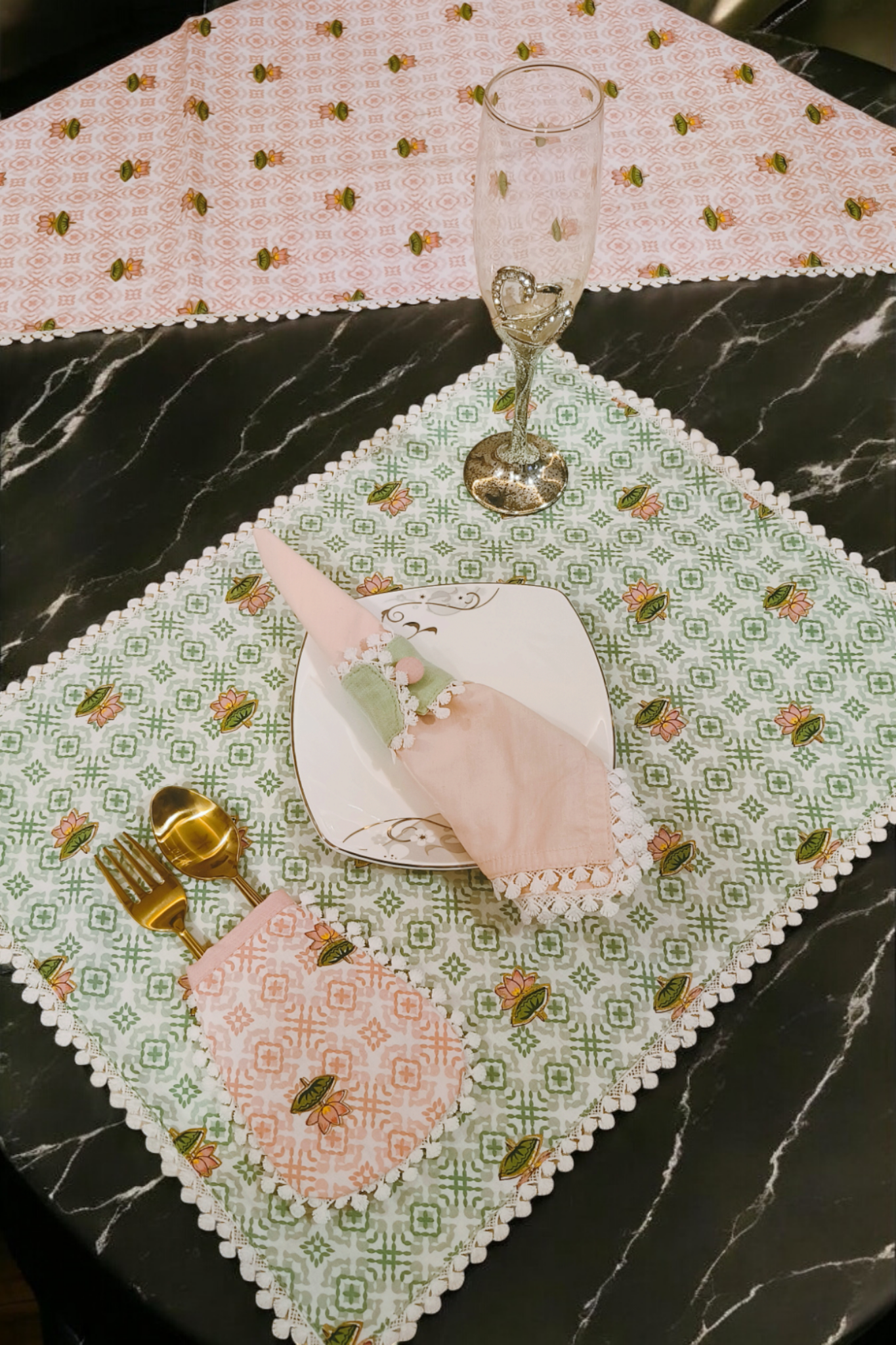 Luxury table runner linen in green with floral pattern and lace edges on black marble table by Samaa India