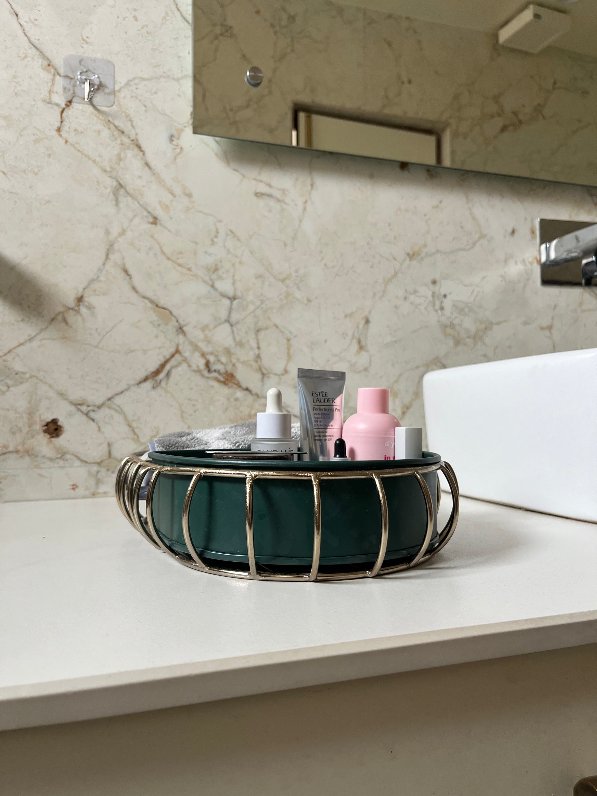 Samaa India metal bathroom vanity tray with decorative design holding skincare bottles on white bathroom countertop