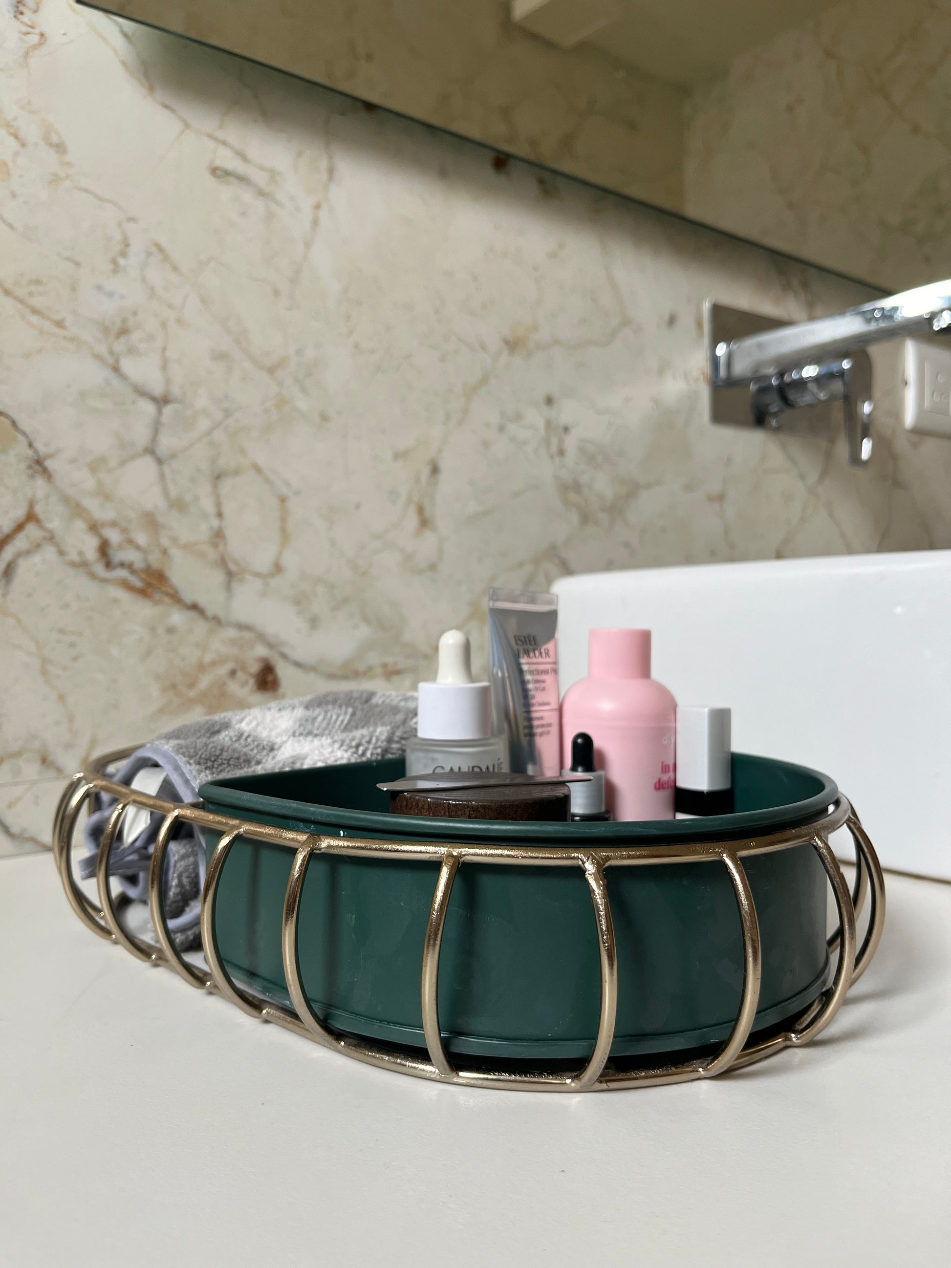 Samaa India metal bathroom vanity tray with green base and gold metal frame holding toiletries on bathroom countertop