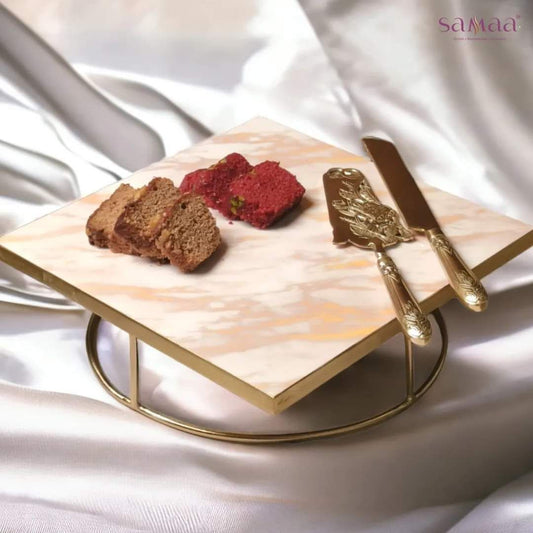 Samaa India marble design cake stand platter with gold metal base holding slices of cake and ornate gold serving utensils